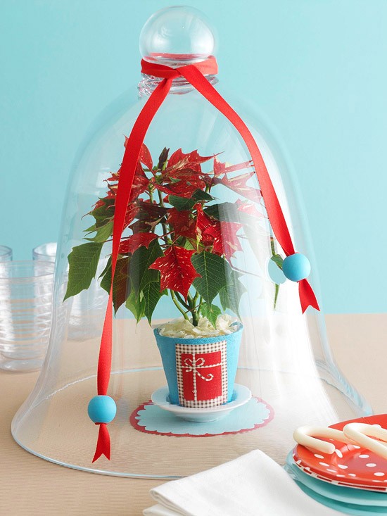 Christmas table ornaments under glass and red ribbons