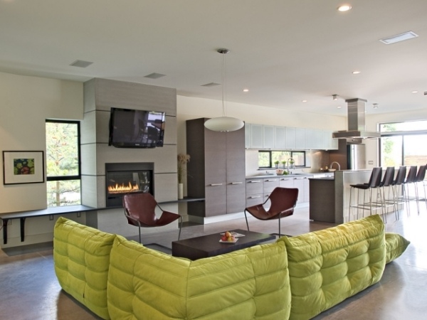 living-room-kitchen-open-green-sofa-fireplace-center-focal-point