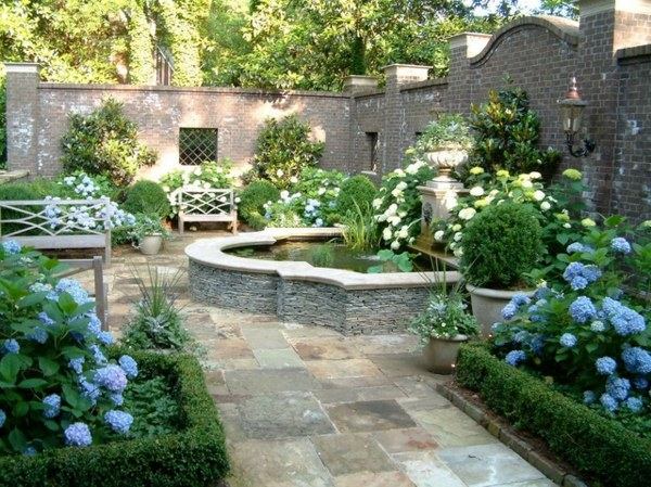 secret-garden-design-idea-small-pond-flowerbeds-wooden-bench-high-stone-wall