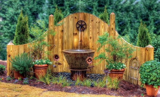  country style design evergreen plants rocks wooden fountain