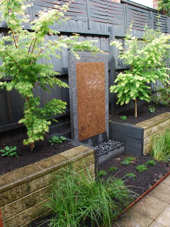 Water wall garden design ideas evergreen plants trees stone wall