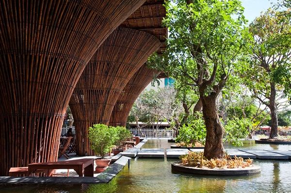 creative architecture surrouded by water bamboo pillars