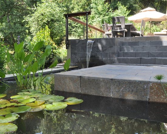 modern patio landscape design stone terrace lily pond small waterfall