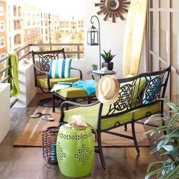 small balcony with wrought iron furniture green upholstery