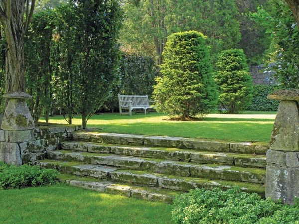 English garden design green lawn stone steps bench