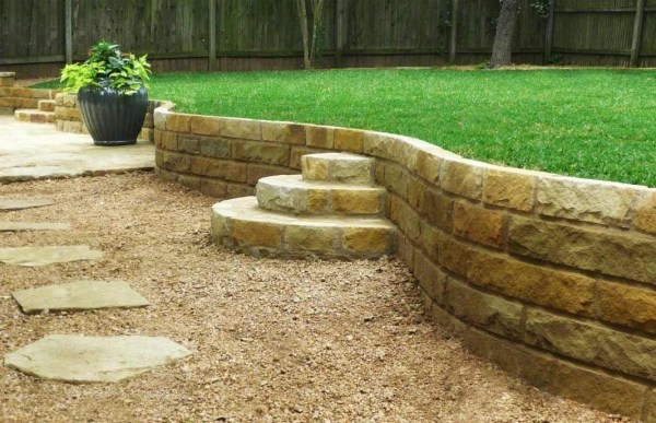 Sandstone wall green lawn stepping stones