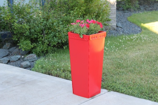 red self-watering flower pot garden path