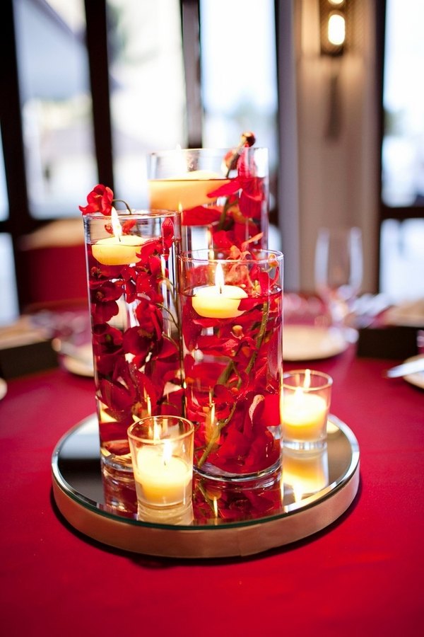 DIY centerpiece idea glass candle containers floating red flowers