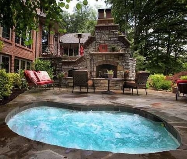 kidney shaped inground jacuzzi fireplace outdoor dining area