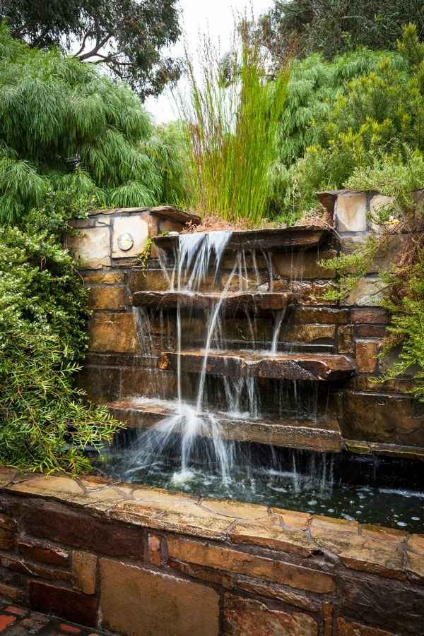 natural look waterfall green landscape outdoor area natural stone wall water feature