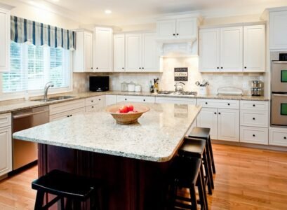 new-venetian-gold-granite-countertops-white-cabinets-dark-island-wood-flooring