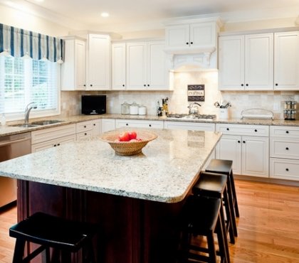 new-venetian-gold-granite-countertops-white-cabinets-dark-island-wood-flooring