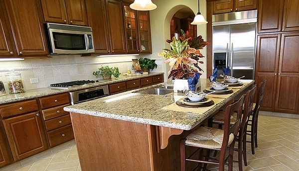 Santa-Cecilia-granite-countertops-kitchen-island-with-seating-dark-wood-cabinets