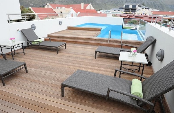 small rooftop pool wooden deck sun loungers
