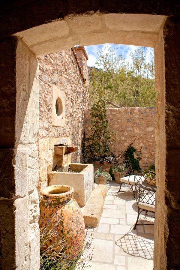 Patio ideas stone wall terracotta pots metal chairs 