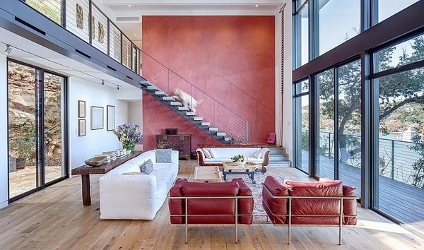 red accent wall open floor plan living room large windows modern home design Cliff dwelling