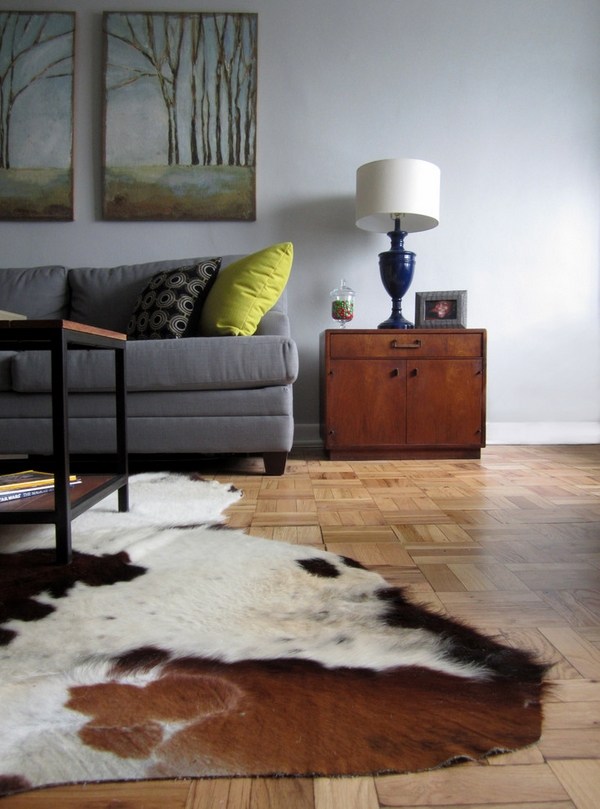 gray sofa cowhide rug wall paintings