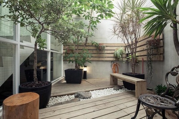 asian inspired wooden deck gravel potted plants wooden garden bench
