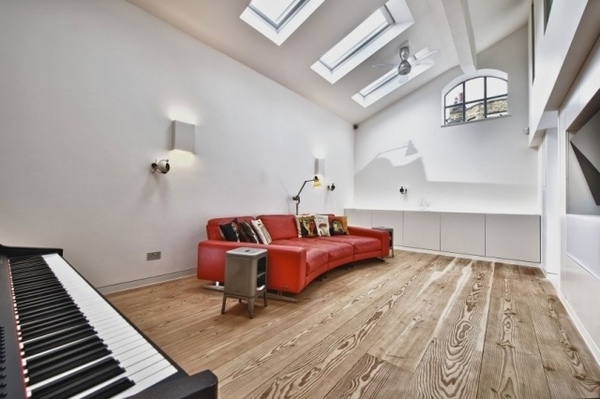 attic music room wood floor skylights modern red sofa piano
