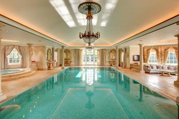 amazing indoor pool with chandelier and seating area
