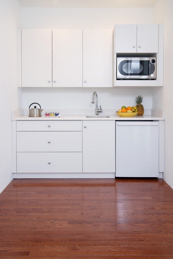 modern space saving white mini kitchen with small refrigerator