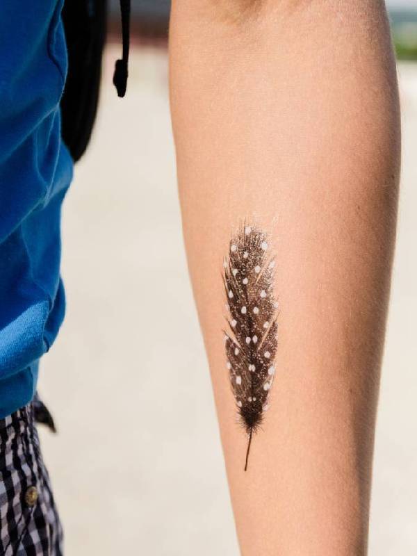 unique feather tattoo on forearm ideas for men and women