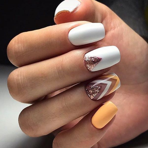 white nail art with yellow and gold accents