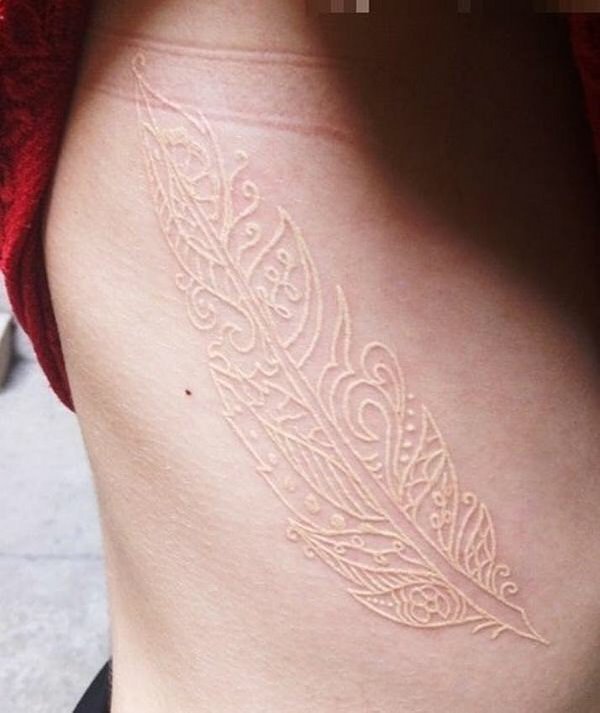 tribal style white ink feather tattoo on ribs
