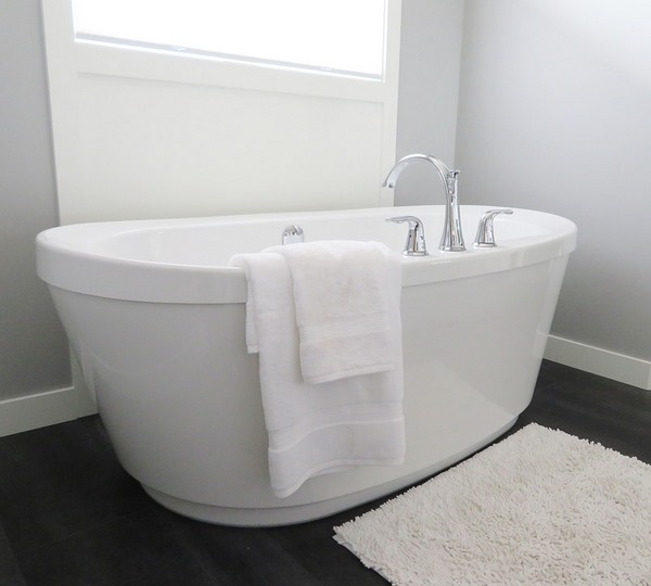 modern freestanding tub oval shape dark flooring