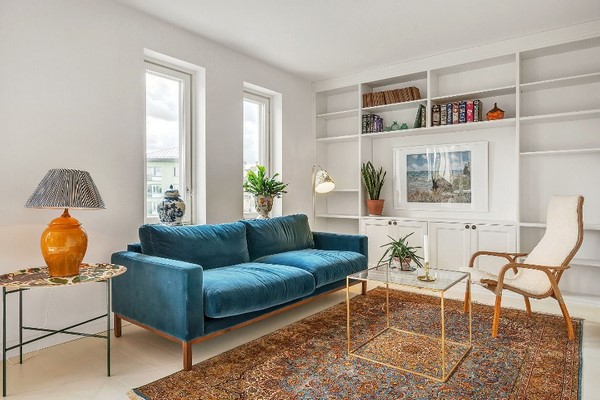 modern living room teal sofa vintage rug built in shelves