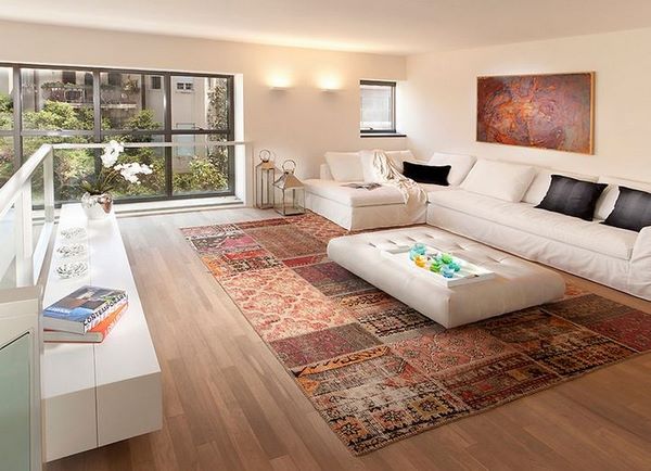 modern living room with white furniture and vintage rug on wood flooring