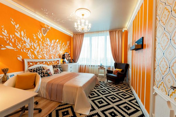 bright orange wall color in master bedroom geometric pattern carpet