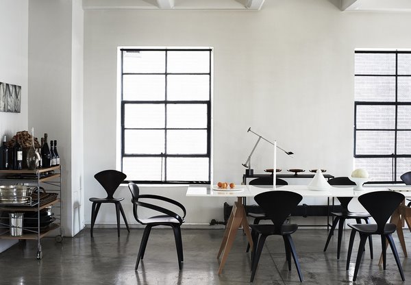 monochromatic dining room gray concrete floor white walls black dining chairs
