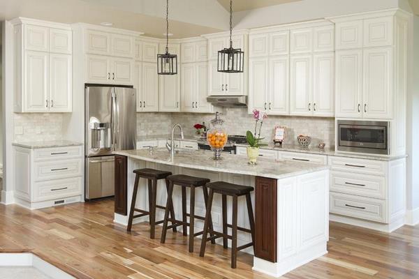 L shaped kitchen with white cabinets and wood flooring