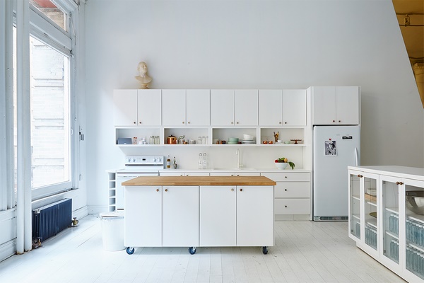 small white kitchen with movable island with storage cabinets