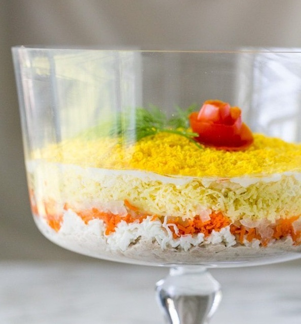 Mimosa salad in transparent bowl