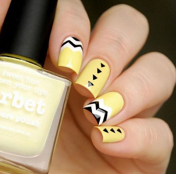 yellow manicure with black geometric patterns