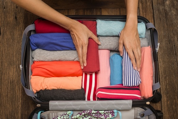 packing suitcase rolling clothes to save space in suitcase