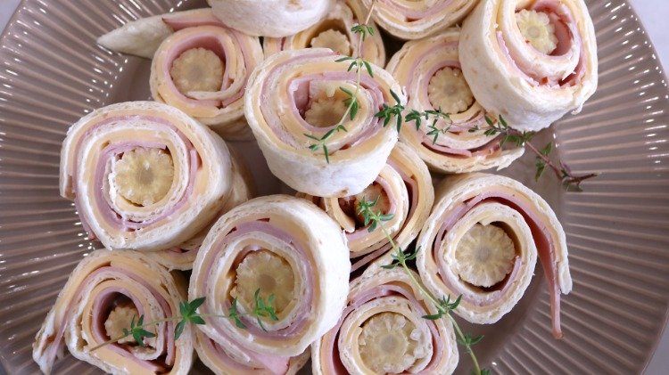 savory finger food cheese ham rolls topped with thyme sprigs