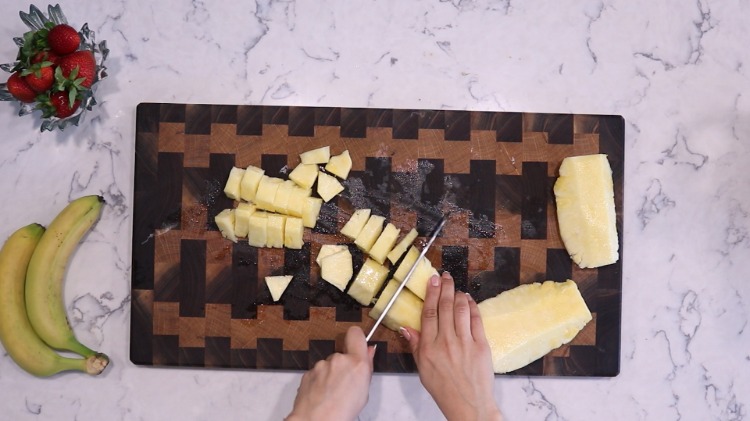 strawberry banana and pineapple on kitchen board 