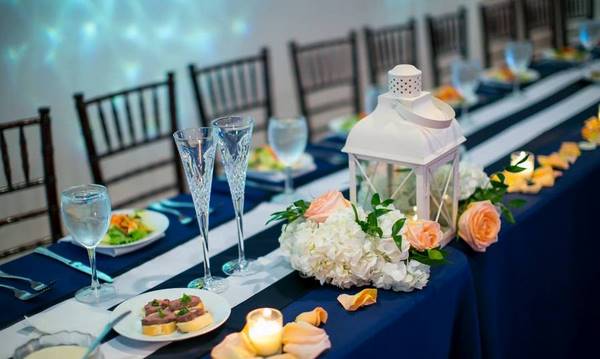table decorations in blue white and roses for wedding at the beach