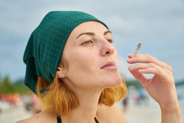 woman smoking cigarette on the beach