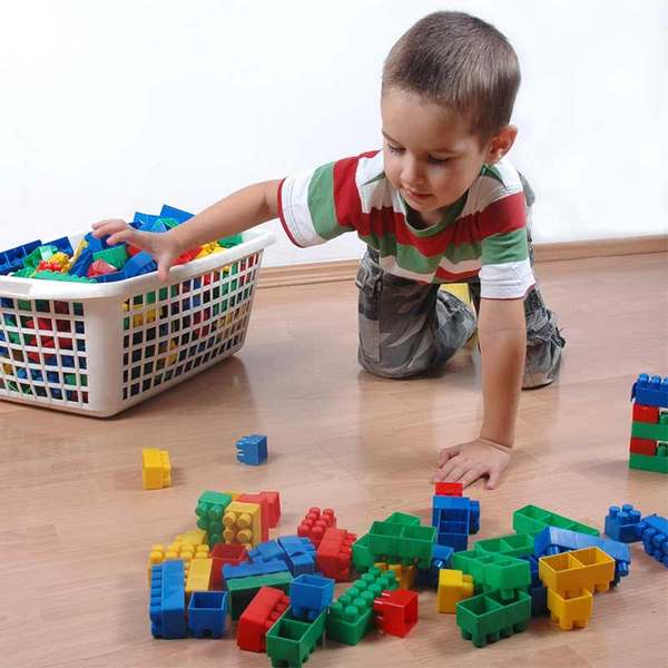 Boy gathering blocks in basket