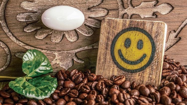 coffee beans and smiley with green leaf on rustic background