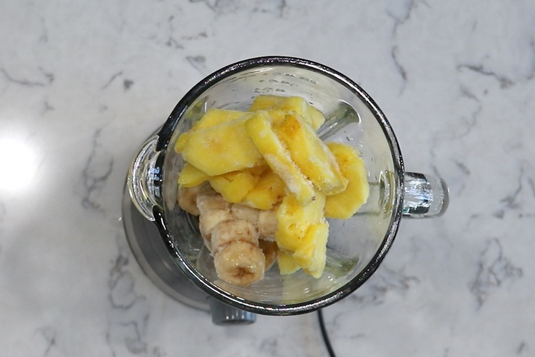 frozen banana and pineapple in blender bowl