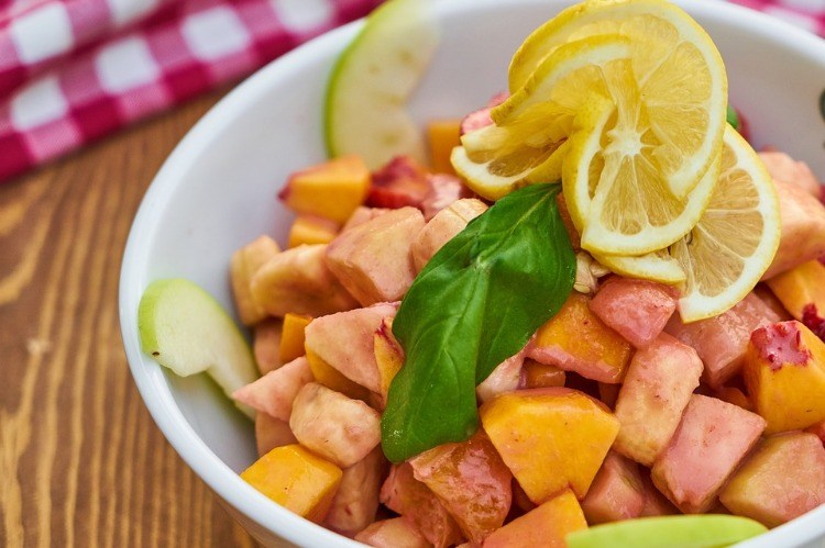 fruit pieces in bowl peach pineapple lemon apples for vegan diet food