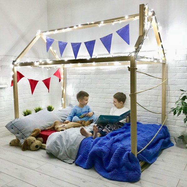 house bed decorated with banner and string lights low bed Montessori bedroom ideas