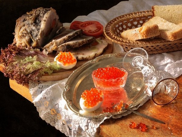 platter with caviar in glass bowl and bread in basket