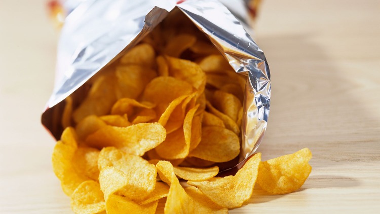 potato chips out of package on a table harmful foods
