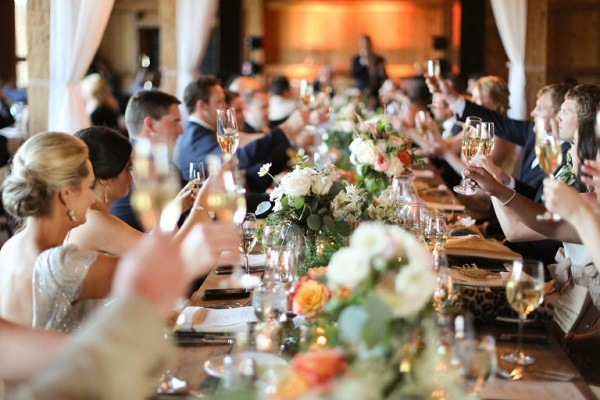 wedding guests seated at table holding glasses